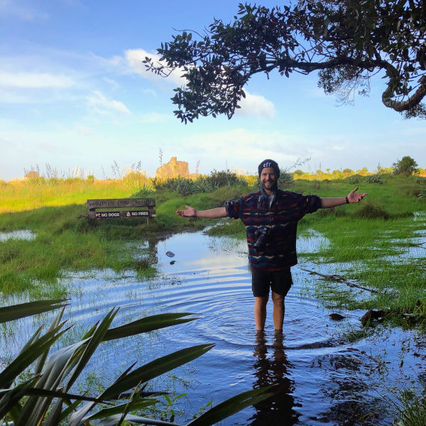 Ieuan standing on a flooded footpath at Whatipu scientific reserve.